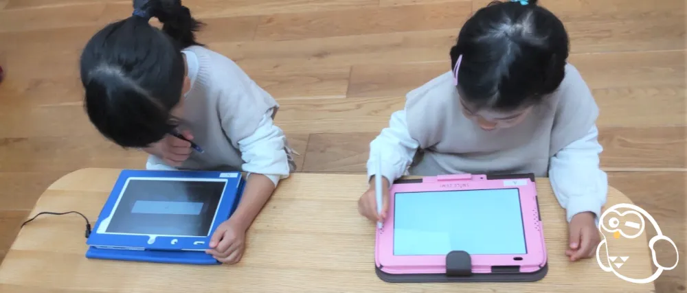 スマイルゼミとチャレンジタッチをしている姉妹